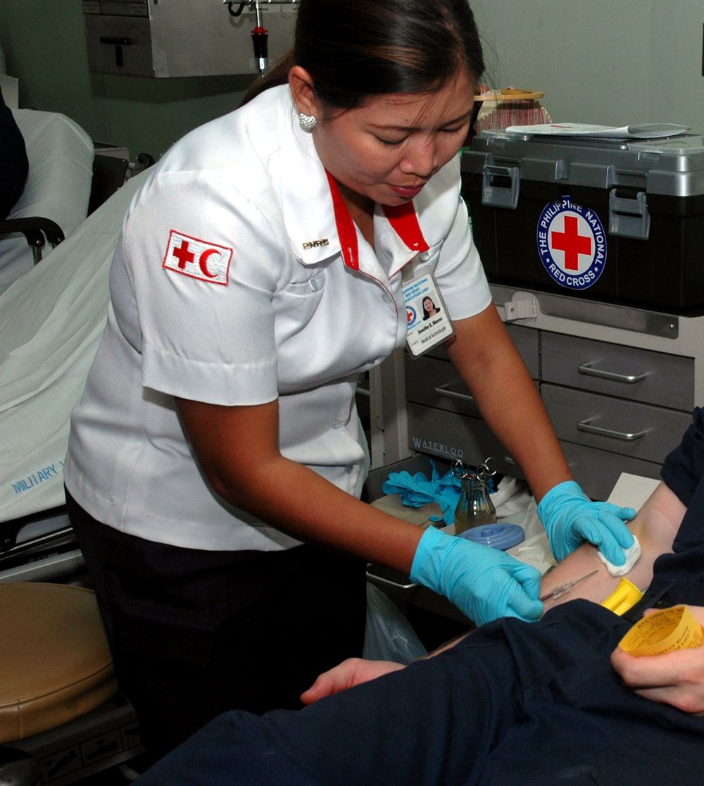 A Philippine Red Cross nurse drawing blood from a donor