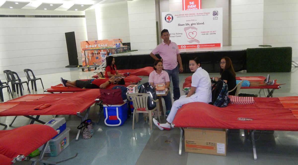 Donors resting on cots while Philippine Red Cross staff attend to them at a mall blood drive